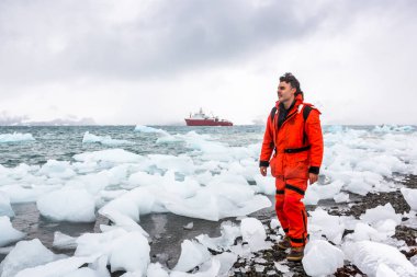 Adam buz ve Antarktika karda yürür. Buzdağları ve her şey etrafında donmuş. Soğuk.