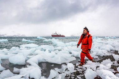 Adam buz ve Antarktika karda yürür. Buzdağları ve her şey etrafında donmuş. Soğuk.