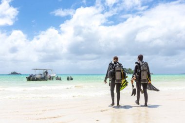 Divers Walking on Beach in Seychelles. clipart