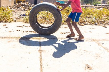 Etiyopya. Afrika'nın fakir şehirde lastik ile oynayan çocuk.