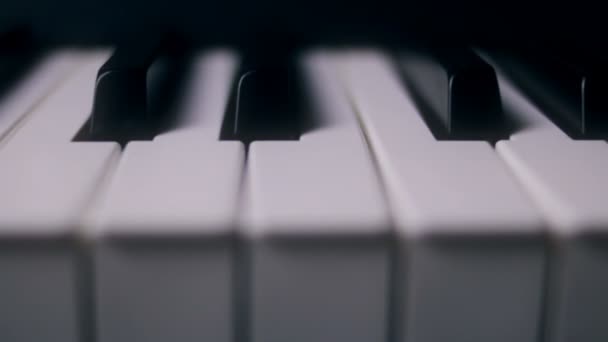 Klaviertasten auf dunklem Hintergrund in Bewegung — Stockvideo