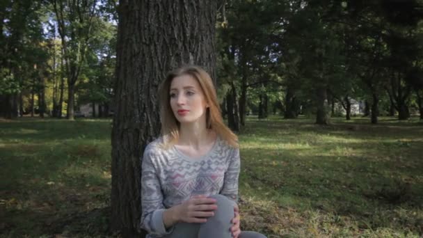 Seule fille sous forme de sport s'ennuie assis sous un arbre — Video