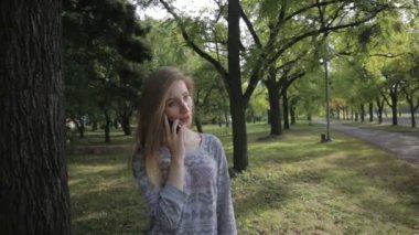 Genç kız açık havada telefonda konuşurken