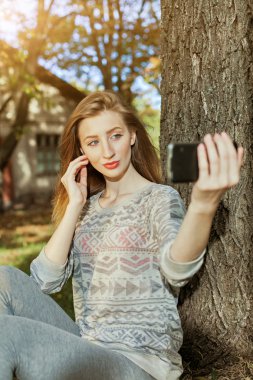 Mavi gözlü güzel kız açık havada selfie yapar
