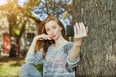 Mavi gözlü güzel kız açık havada selfie yapar