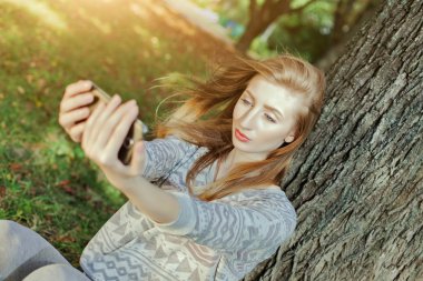Mavi gözlü güzel kız açık havada selfie yapar
