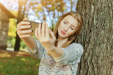 Mavi gözlü güzel kız açık havada selfie yapar