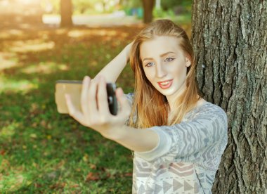Mavi gözlü güzel kız açık havada selfie yapar