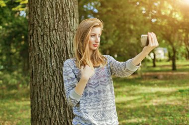 Mavi gözlü güzel kız açık havada selfie yapar