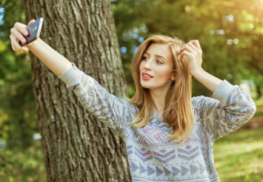 Mavi gözlü güzel kız açık havada selfie yapar
