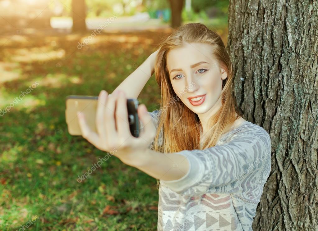Beautiful Girl With Blue Eyes Makes Selfie Outdoors Stock Photo