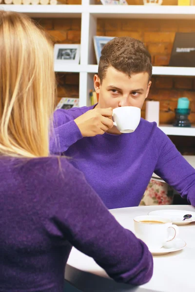 Young man drinking coffee and talking with a woman. Nice meeting friends or lovers. — Stock Photo, Image