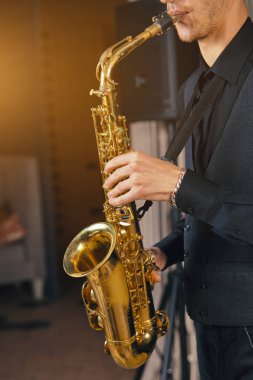 Elbiseli genç adam tutun saksafon