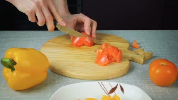 Chica con un cuchillo corta un tomate rojo — Vídeos de Stock