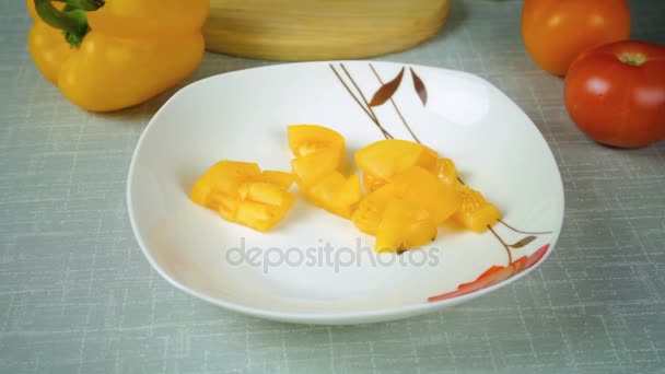 Девушка лежит на тарелке, вымытой желтым нарезанным помидором — стоковое видео