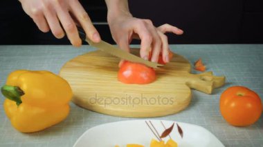 Kırmızı domates kız bir bıçakla keser