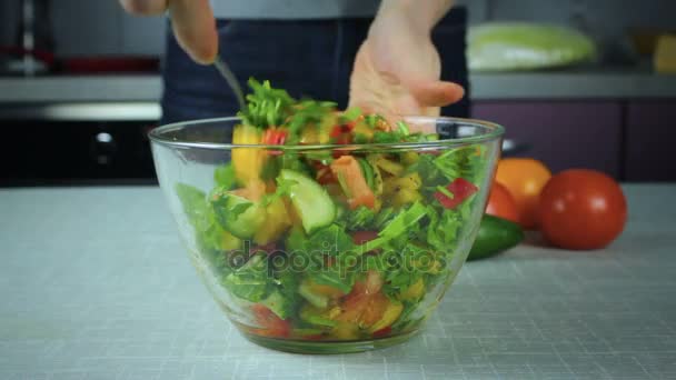 Chica cocinero revuelve la ensalada en el plato — Vídeo de stock