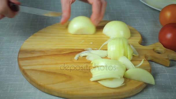 Chef corta un trozo de cebolla amarilla en una tabla de madera — Vídeo de stock