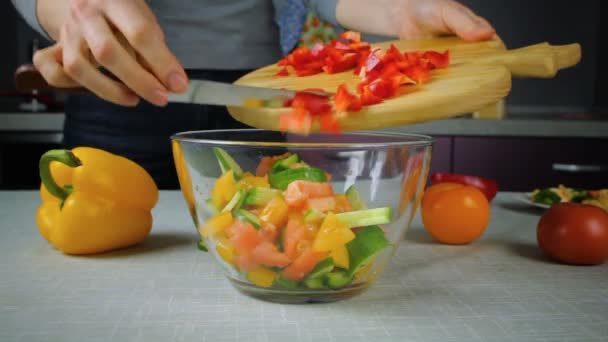 Cook giet in een kom salade ingrediënten — Stockvideo