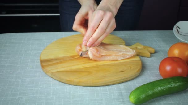 Fille coupe un morceau de poulet cru — Video