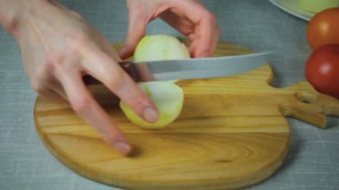 Şef sarı soğan bir parça ahşap bir gemide keser.