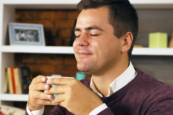 Young man drink coffee, tea or chocolate