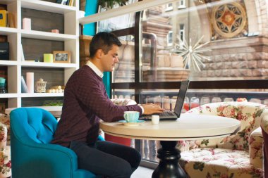 Gülümseyerek mutlu bir genç adam ve onun laptop üzerinde çalışır