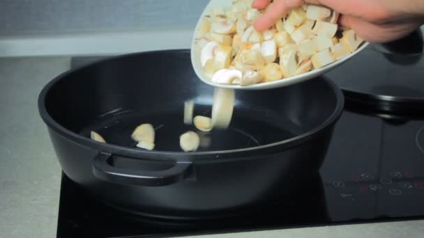 Cook puts the mushrooms to the frying pan — Stock Video