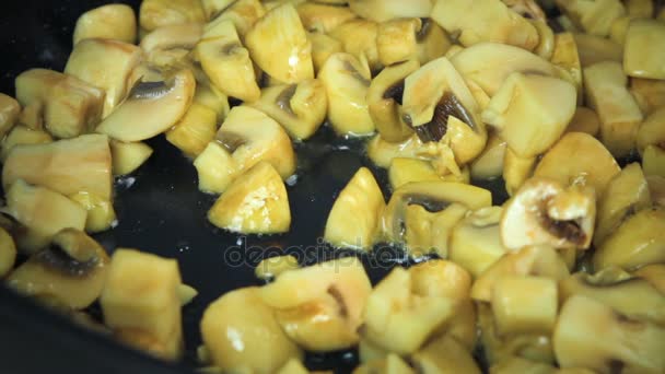 Грибы жареные с маслом в сковороде — стоковое видео