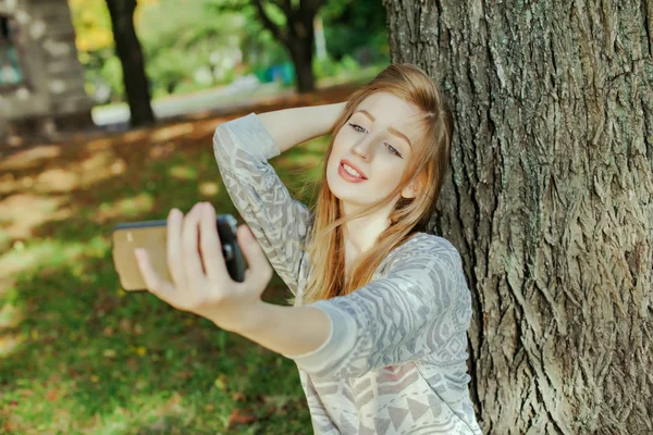 Mooi meisje met blauwe ogen maakt selfie buitenshuis — Stockfoto