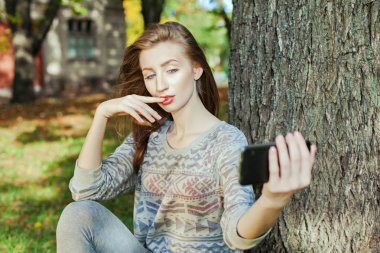 Mavi gözlü güzel kız açık havada selfie yapar