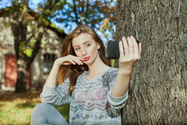 Mavi gözlü güzel kız açık havada selfie yapar