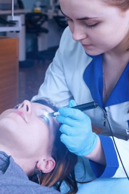 Göz doktoru bir genç kız görme teşhis etmek için bir işlem gerçekleştirir.