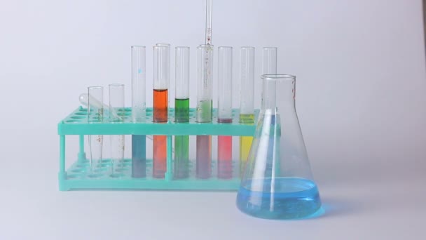 Frascos de laboratorio y vasos de precipitados sobre la mesa — Vídeos de Stock