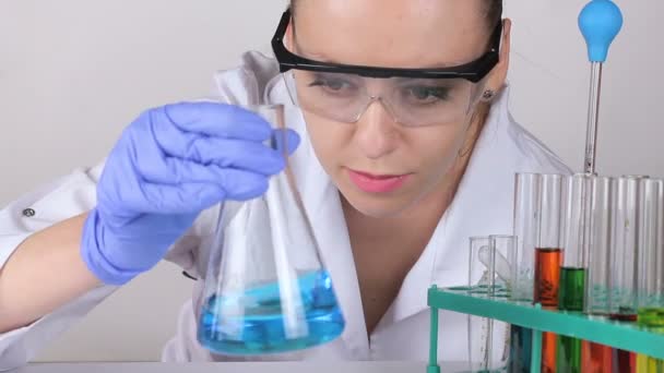 一位年轻的女医生用瓶子搅动液体。. — 图库视频影像