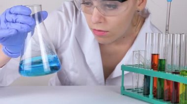 Bir genç kadın doktor sıvı bir şişeye kıpırdanırken..