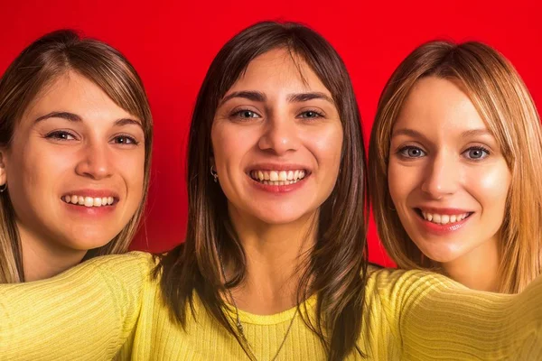 Three girls on a red background