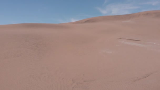 Vue aérienne des dunes allant jusqu'au sommet sans trouver d'empreintes de pas. Le ciel avec quelques nuages .