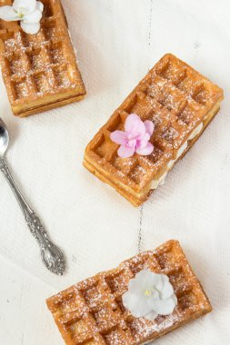 Belçika waffle buzlanma ile serpilir, pembe çiçekler. 