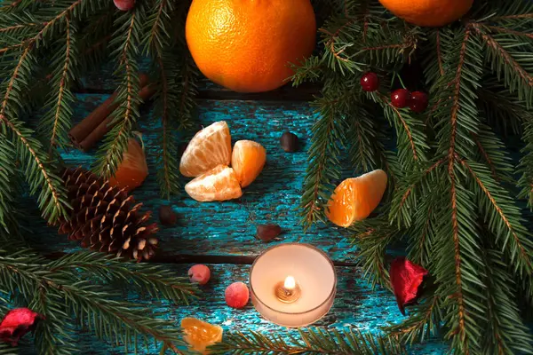 Still life of spruce branches, tangerine, pine cones, pine nuts. — Stock Photo, Image