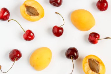 Kiraz ve kayısı beyaz bir arka plan üzerinde.