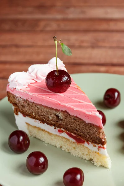 Chocolate cake with cherries on wooden background Stock Photo