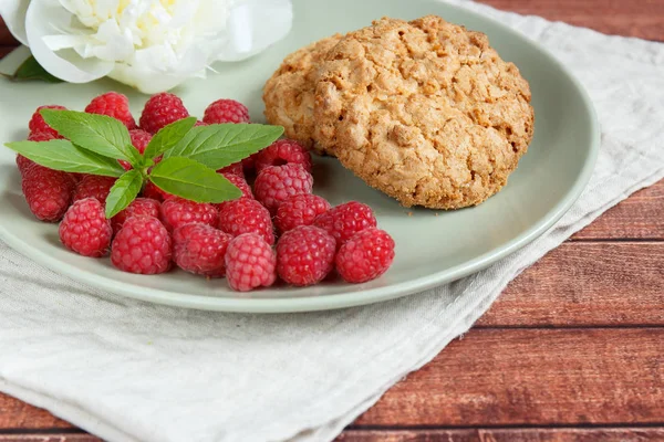 Delicious cookies with raspberries, mint and white peony flower on the plate. — Stock Photo, Image