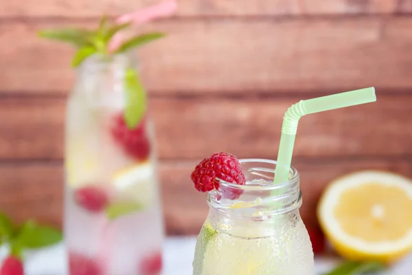 Cold cocktail with raspberries, lemon and mint. Wooden background — Stock Photo, Image