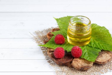 Tatlım, çilek ve ahududu yaprağı bir ahşap stand bir kase. Kaşık bal ile