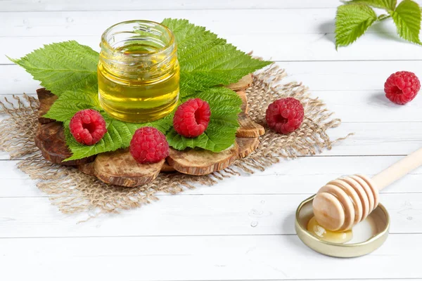 Tatlım, çilek ve ahududu yaprağı bir ahşap stand bir kase. Kaşık bal ile