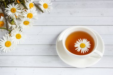 Bir bardak papatya çayı ve bal Beyaz ahşap zemin üzerinde