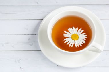 Bir bardak papatya çayı ve bal Beyaz ahşap zemin üzerinde