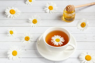 Bir bardak papatya çayı ve bal Beyaz ahşap zemin üzerinde