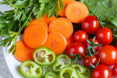 Taze sebze, kiraz domates, yeşil biber havuç Yeşiller bardak ahşap arka plan üzerinde.